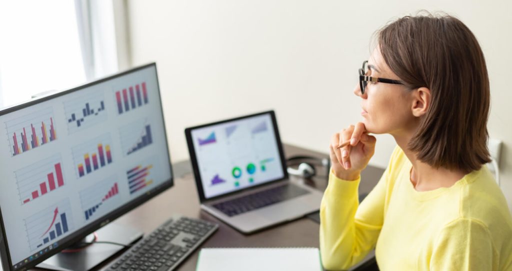 A woman staring at a screen with data visual charts | Best Website Optimization Tools